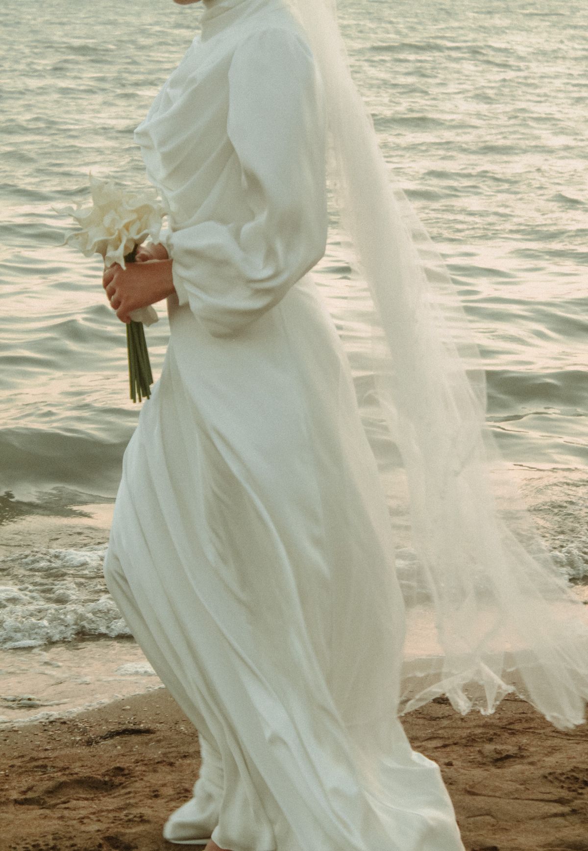 Bride walking by the sea at twilight
